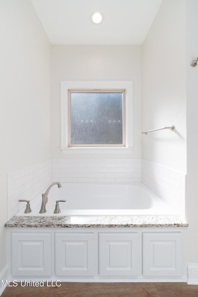 bathroom featuring tiled tub