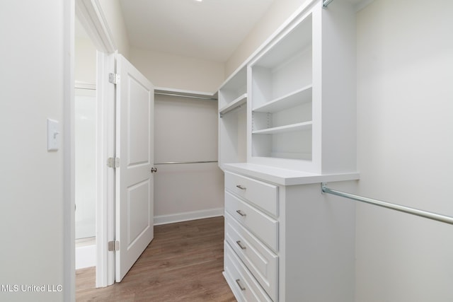 walk in closet with hardwood / wood-style flooring