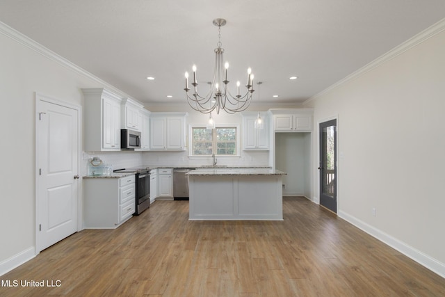 kitchen with hanging light fixtures, stainless steel appliances, a center island, light stone countertops, and white cabinets