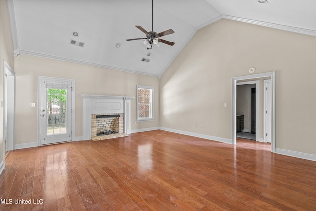 unfurnished living room with a brick fireplace, ceiling fan, high vaulted ceiling, wood finished floors, and baseboards