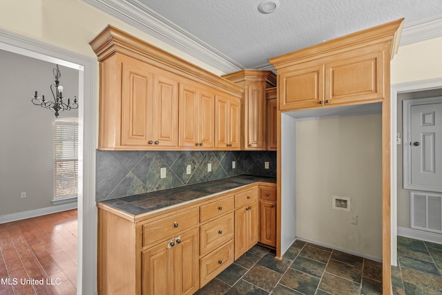 kitchen with baseboards, backsplash, tile countertops, and a chandelier