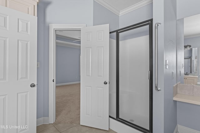 full bathroom with ornamental molding, a stall shower, baseboards, and tile patterned floors