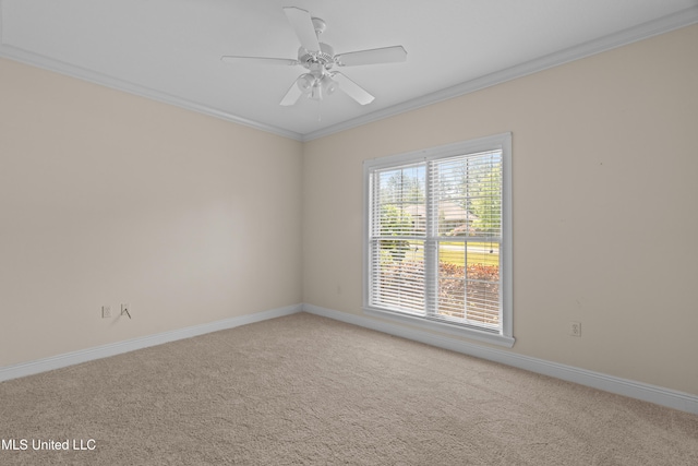 carpeted empty room featuring crown molding, a ceiling fan, and baseboards
