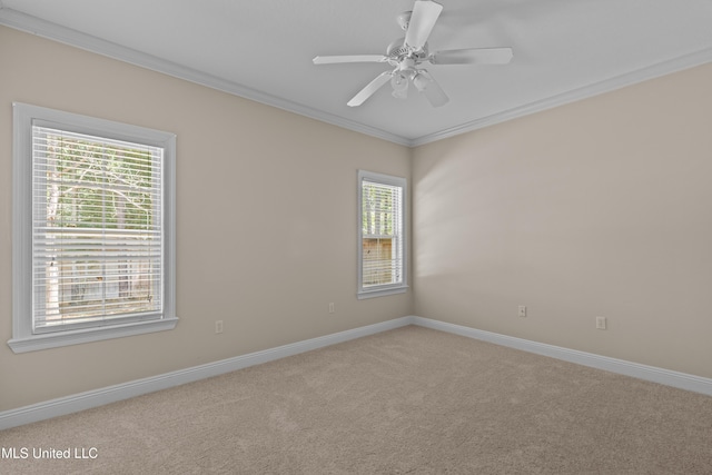 spare room featuring carpet floors, crown molding, plenty of natural light, baseboards, and a ceiling fan