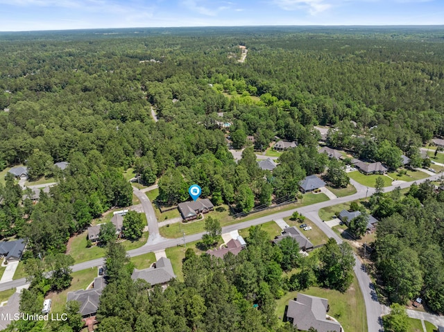 view of property location featuring a heavily wooded area and nearby suburban area