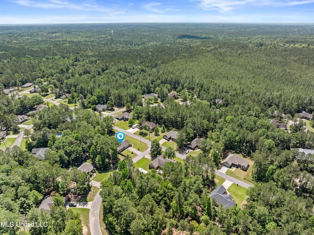aerial overview of property's location featuring a forest and nearby suburban area
