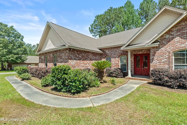 traditional-style house featuring brick siding, a shingled roof, and a front lawn