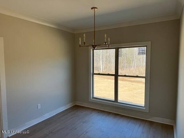 unfurnished dining area with crown molding, dark hardwood / wood-style floors, and a notable chandelier