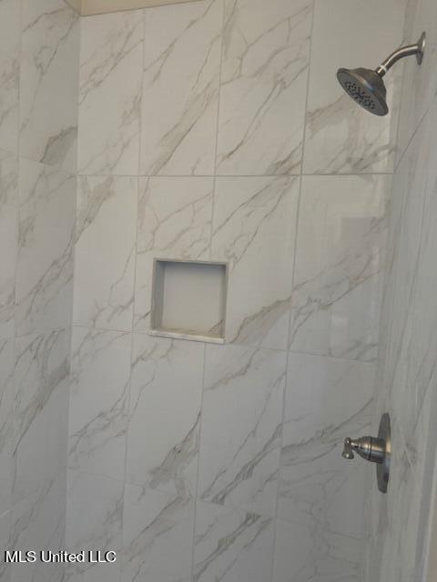 interior details featuring tiled shower