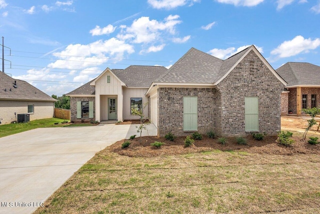 850 Glenwild Cir, Canton, MS 39046 - view of front facade featuring brick siding, a shingled roof, driveway, board and batten siding, and a front lawn