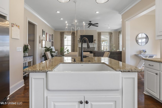 kitchen featuring dark wood-style flooring, crown molding, a sink, light stone countertops, and stainless steel built in refrigerator