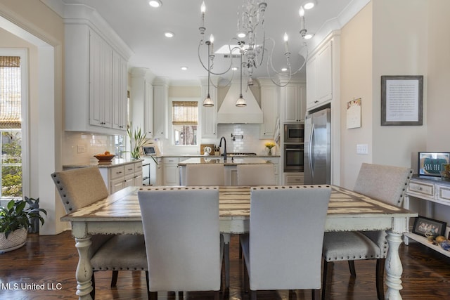 dining room featuring crown molding, a chandelier, dark wood-type flooring, and recessed lighting