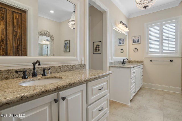 bathroom with a notable chandelier, crown molding, two vanities, and a sink