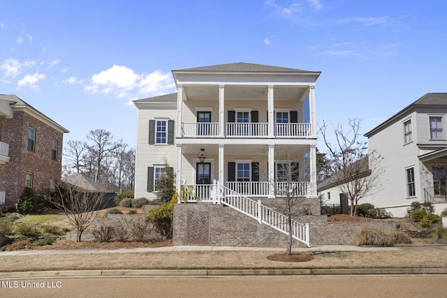 greek revival house with stairway, covered porch, roof with shingles, and a balcony