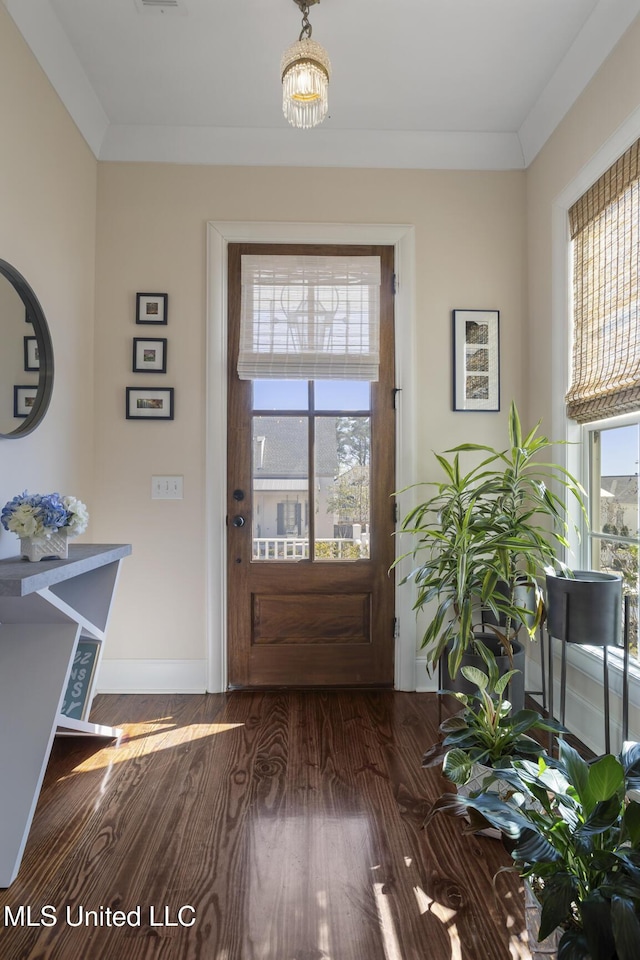 doorway to outside with baseboards, wood finished floors, and crown molding