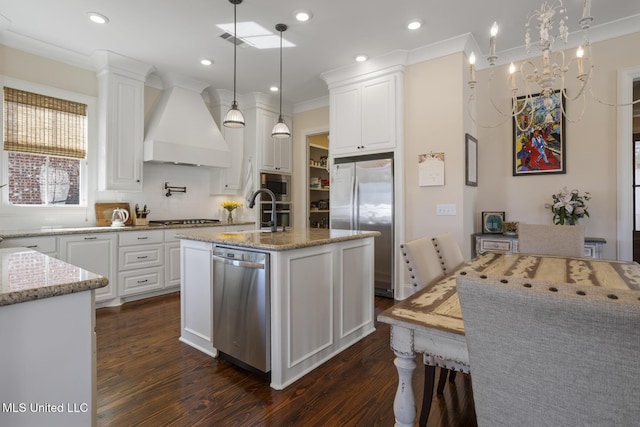 kitchen featuring white cabinetry, custom exhaust hood, stainless steel appliances, and a sink