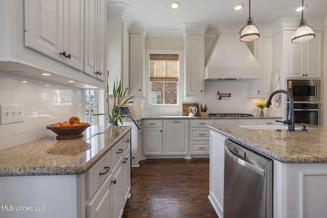 kitchen featuring a sink, stainless steel appliances, custom exhaust hood, and white cabinetry