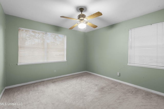 carpeted spare room featuring ceiling fan