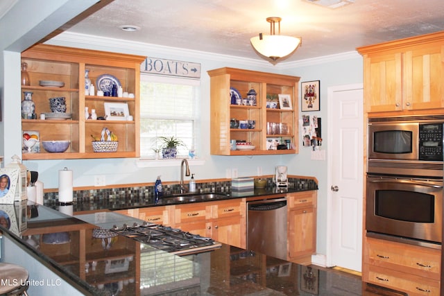 kitchen with sink, ornamental molding, stainless steel appliances, and dark stone counters