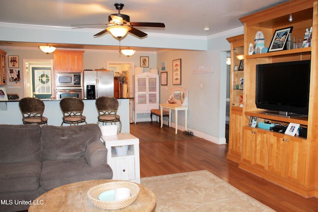 living room featuring ceiling fan, ornamental molding, and dark hardwood / wood-style flooring