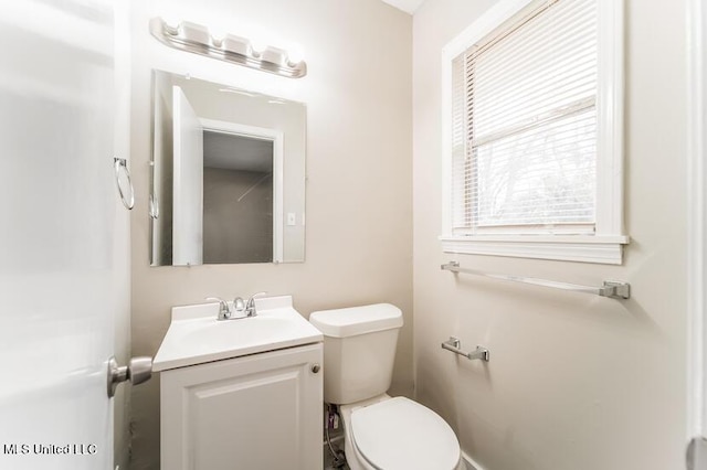 bathroom featuring toilet, a healthy amount of sunlight, and vanity