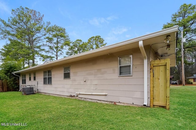 back of property featuring a lawn and central AC