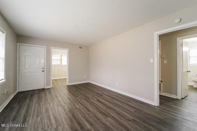 interior space with visible vents, baseboards, and dark wood-type flooring