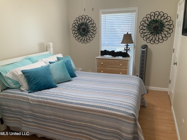 bedroom with baseboards and light wood finished floors