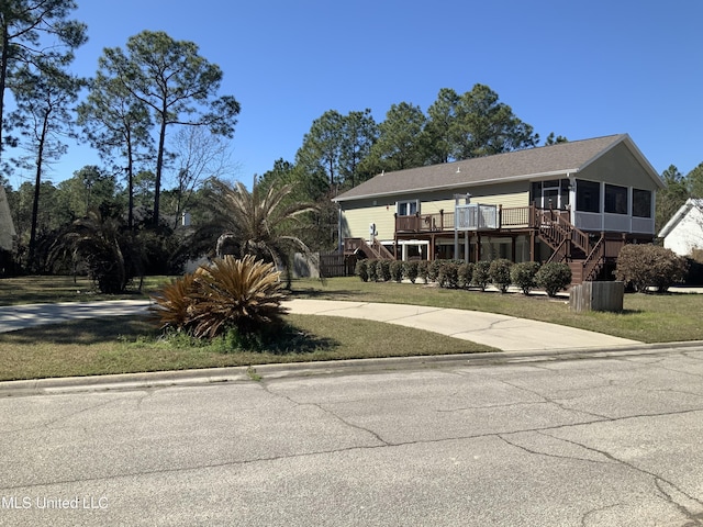 view of front of property with a deck, a sunroom, stairway, and central AC unit