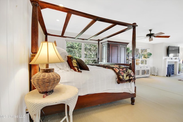 carpeted bedroom with ceiling fan and wood walls