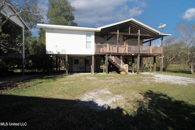 back of property with a deck and a yard