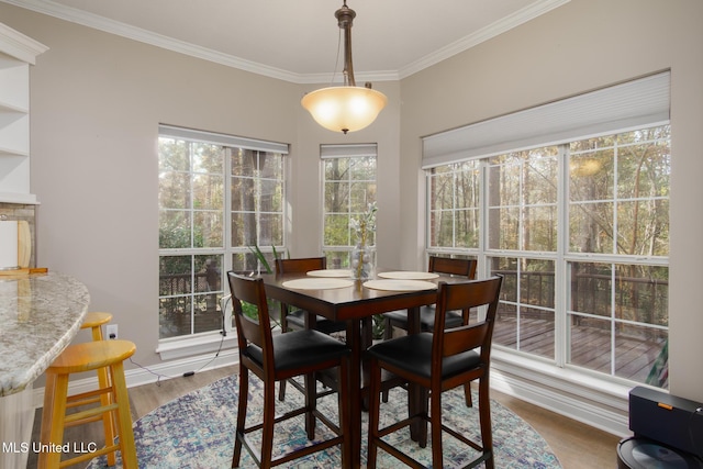 dining area with wood-type flooring, crown molding, and a wealth of natural light