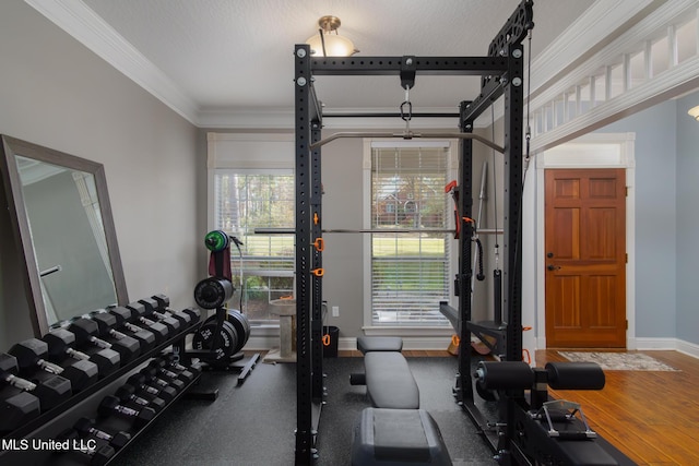 exercise area featuring a wealth of natural light, hardwood / wood-style floors, crown molding, and a textured ceiling