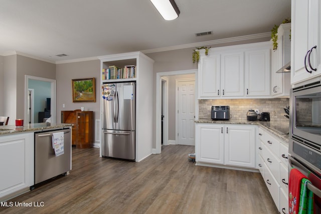 kitchen featuring white cabinets, light stone counters, wood-type flooring, and stainless steel appliances