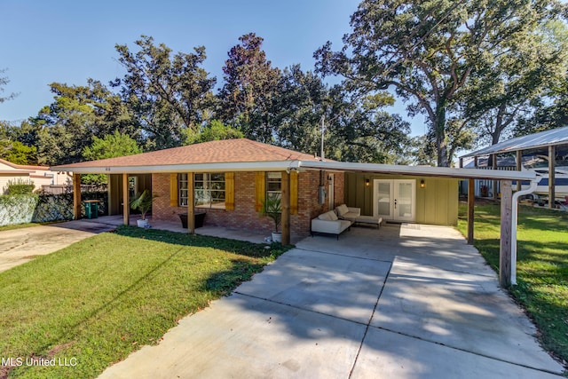 ranch-style home featuring a carport, french doors, and a front lawn