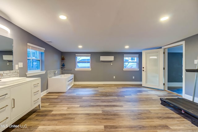 interior space featuring wood-type flooring, a wealth of natural light, and a wall mounted AC