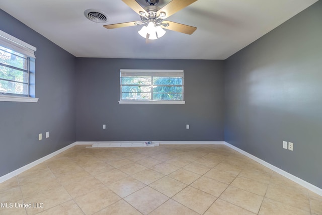 unfurnished room featuring light tile patterned floors, ceiling fan, and a healthy amount of sunlight