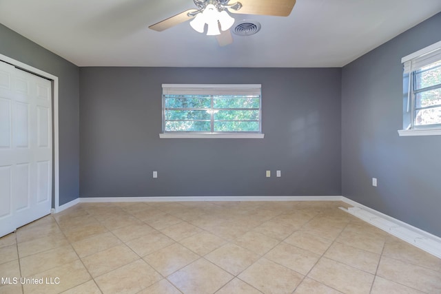 unfurnished bedroom featuring light tile patterned floors, a closet, and ceiling fan