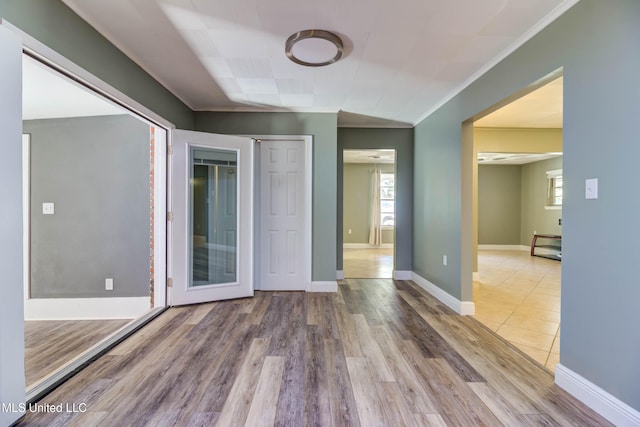 empty room with wood-type flooring and crown molding