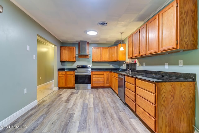 kitchen featuring sink, wall chimney exhaust hood, stainless steel appliances, decorative light fixtures, and light wood-type flooring