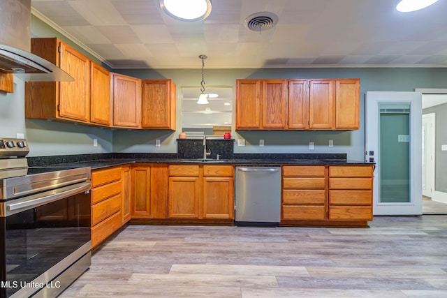 kitchen featuring sink, hanging light fixtures, wall chimney exhaust hood, light wood-type flooring, and stainless steel appliances