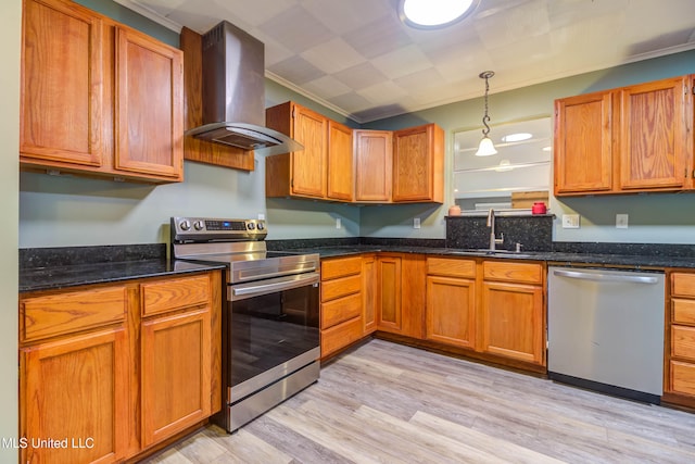 kitchen featuring sink, wall chimney exhaust hood, light hardwood / wood-style flooring, crown molding, and appliances with stainless steel finishes