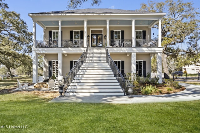 view of front of property with a porch, a front yard, and stairway