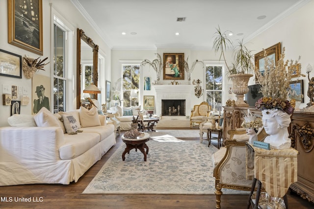 living area featuring ornamental molding, a wealth of natural light, a brick fireplace, and wood finished floors