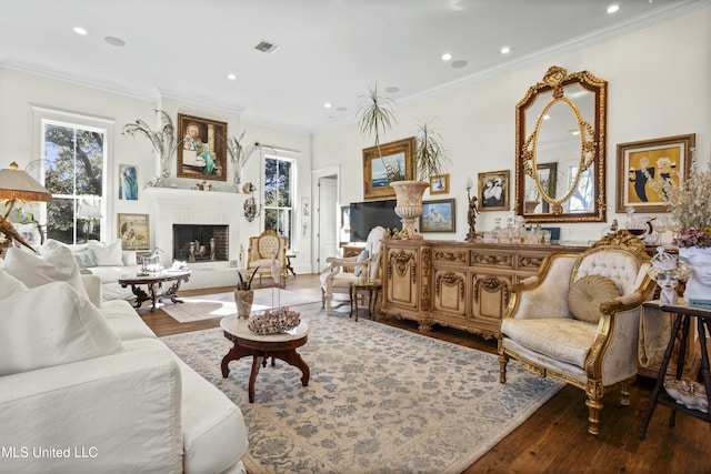 living area with recessed lighting, wood finished floors, visible vents, ornamental molding, and a brick fireplace