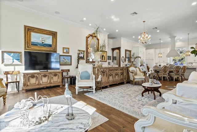 living room with ornamental molding, dark wood-type flooring, visible vents, and a notable chandelier