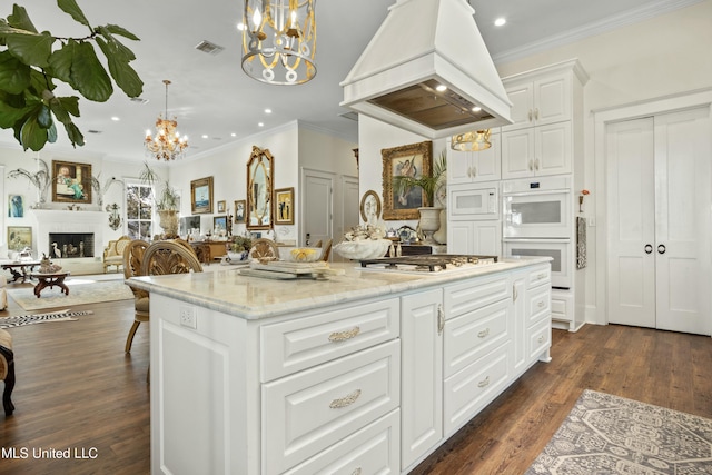 kitchen featuring premium range hood, white appliances, a fireplace, visible vents, and dark wood finished floors