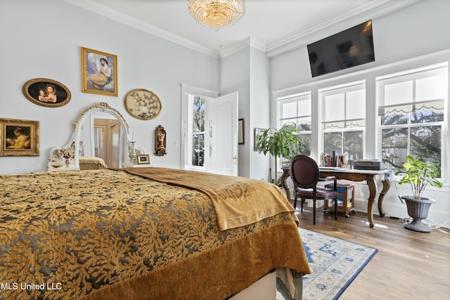 bedroom with a towering ceiling, a notable chandelier, crown molding, and wood finished floors