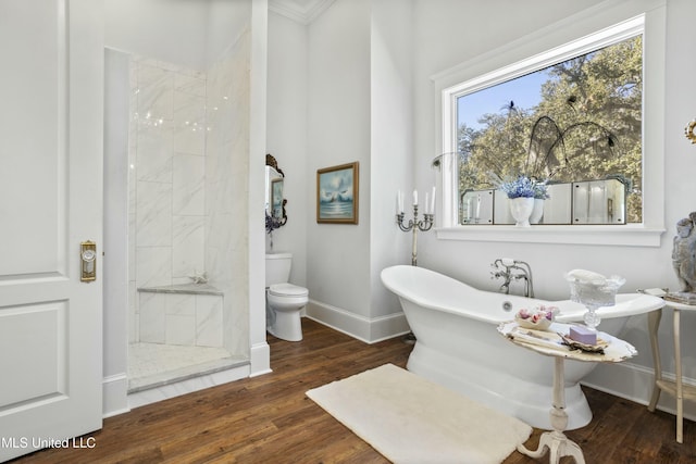 full bathroom featuring baseboards, toilet, wood finished floors, a tile shower, and a freestanding bath