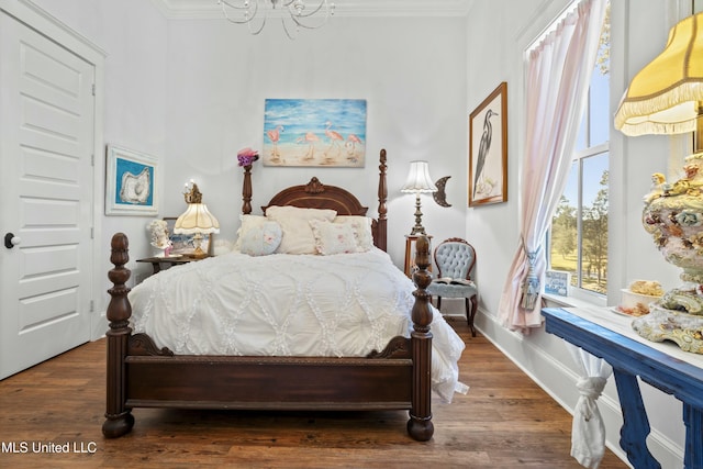 bedroom featuring baseboards, ornamental molding, and wood finished floors